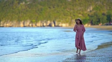 Deniz kıyısındaki güzel Asyalı genç kadının görüntüleri.