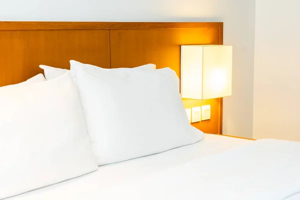 Bianco comodo cuscino sul letto con decorazione lampada luce in essere — Foto Stock