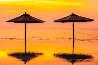 Şemsiye ve sandalye yüzme havuzu yakınında deniz okyanus plaj