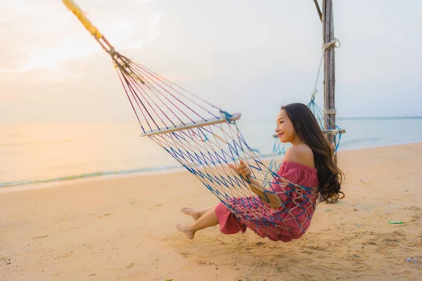 Retrato bela jovem mulher asiática sentado na rede com — Fotografia de Stock