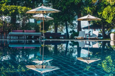 Güzel lüks otel ve tatil seyahat ve tatil için sandalye ve şemsiye ile açık yüzme havuzu