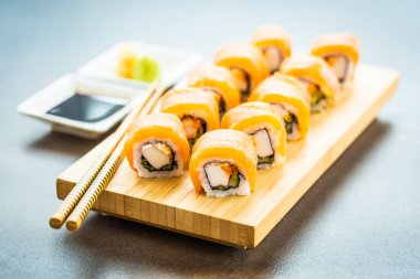 Somon Balık et suşi roll maki wasabi ve soya sosu - Japon yemekleri tarzı ahşap plaka üzerinde