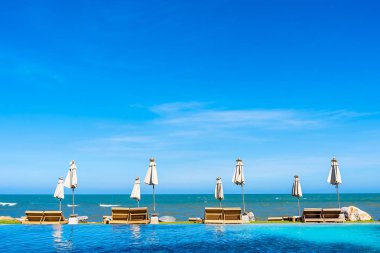 Güzel açık doğa manzara ile yatak şezlong otel tatil için seyahat ve tatil kavramı mavi gökyüzü arka plan üzerinde Yüzme Havuzu etrafında