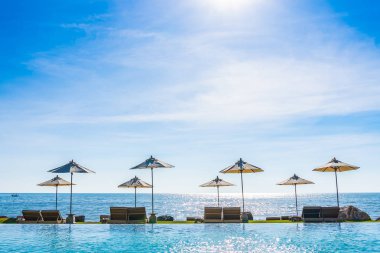 Deniz okyanus üzerinde sky şemsiye ve lüks Açık Yüzme havuzunda hotel resort tatil seyahat ve tatil için çevresinde sandalye ile güzel manzara