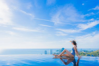 Tatil tatilinde eğlence seyahat etmek için deniz ve okyanus manzaralı havuz güzel genç kız gülümsemek mutlu tatil tatil