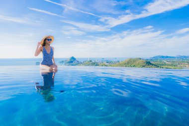 Tatil tatilinde eğlence seyahat etmek için deniz ve okyanus manzaralı havuz güzel genç kız gülümsemek mutlu tatil tatil