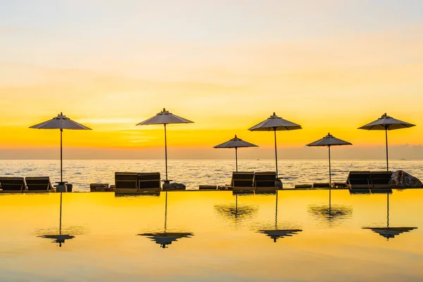 日落或日出时 可在度假酒店的游泳池周围放置雨伞和椅子 供游玩及度假之用 — 图库照片
