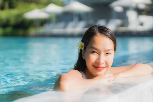 Portrait beautiful young asian woman happy smile in swimming pool around resort and hotel for travel vacation and leisure