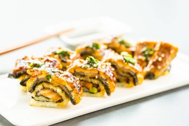 Somon ve beyaz plaka - Japon yemekleri stil üzerinde suşi maki rulo ve tatlı sos içinde sebze ızgara yılan balığı veya unagi balık