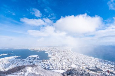 Güzel manzara ve şehir manzarası kurma ve mavi gökyüzü beyaz bulut mimarisiyle etrafa bakmak için gelen dağ Hakodate cityscape