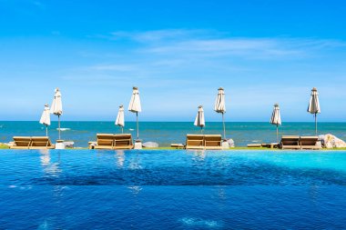 Güzel açık doğa manzara ile yatak şezlong otel tatil için seyahat ve tatil kavramı mavi gökyüzü arka plan üzerinde Yüzme Havuzu etrafında