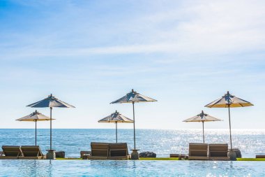 Deniz okyanus üzerinde sky şemsiye ve lüks Açık Yüzme havuzunda hotel resort tatil seyahat ve tatil için çevresinde sandalye ile güzel manzara