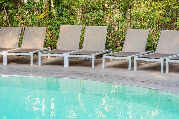 旅行レジャーや休暇のコンセプトのためのホテルリゾートのスイミングプールの周りの空の椅子 — ストック写真