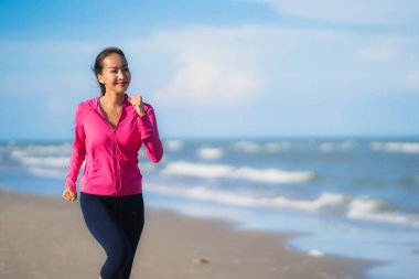 Portre güzel genç Asyalı kadın çalışan ve sağlıklı için tropikal açık doğa plaj deniz Okyanusu üzerinde egzersiz
