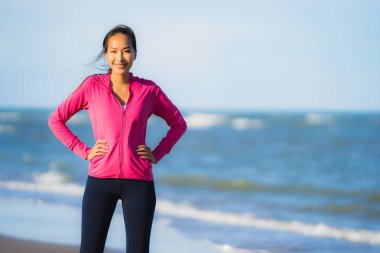 Portre güzel genç Asyalı kadın çalışan ve sağlıklı için tropikal açık doğa plaj deniz Okyanusu üzerinde egzersiz