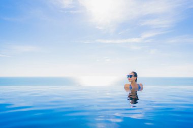 Tatil tatilinde eğlence seyahat etmek için deniz ve okyanus manzaralı havuz güzel genç kız gülümsemek mutlu tatil tatil