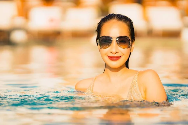 ポートレート若い美しいアジアの女性幸せな笑顔と休日の休暇でレジャー旅行のためのホテルリゾートの周りのスイミングプールでリラックス — ストック写真