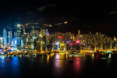 Hong Kong şehrinin dış şehir manzarası geceleri gökyüzüne yükseliyor.