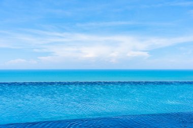 Tatil tatilinde boş tatil için beyaz bulut mavi gökyüzü görünümü üzerinde deniz okyanusu ile otel beldesinde sonsuzluk yüzme havuzu güzel açık manzara