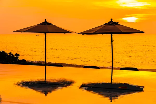 在日出或日落时分 在海边海滩附近的游泳池周围使用雨伞和椅子 供休闲旅行和度假 — 图库照片