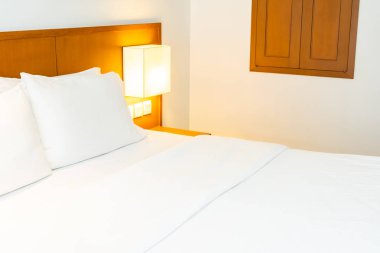 Hafif lamba dekorasyonu ile yatakta beyaz rahat yastık olmak