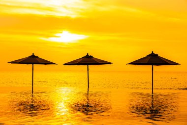 Şemsiye ve sandalye yüzme havuzu yakınında deniz okyanus plaj