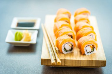 Somon Balık et suşi roll maki ahşap plaka üzerinde