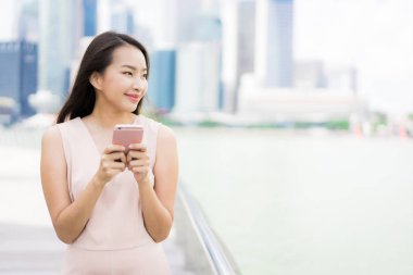 Asyalı kadın konuşmak veya metin için akıllı telefon veya cep telefonu kullanarak