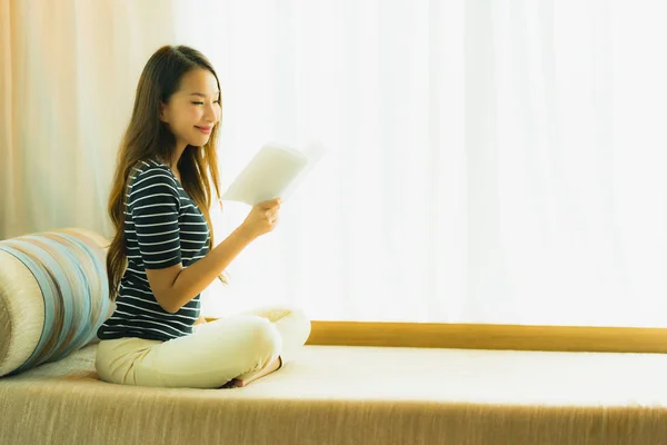 Ritratto bella giovane donna asiatica lettura libro su divano in — Foto Stock