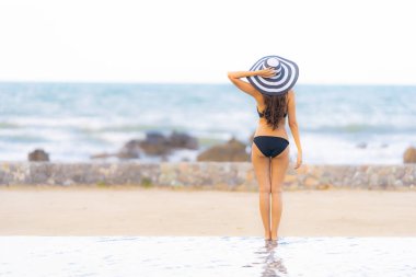 Portre güzel genç Asyalı kadın yüzme etrafında bikini giymek
