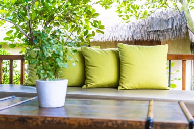 Koltuk koltuğu üzerinde yastık ile masa dekorasyonu vazo bitki