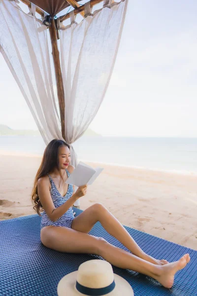 Портрет красивая молодая азиатская женщина читает книгу с счастливым smi — стоковое фото