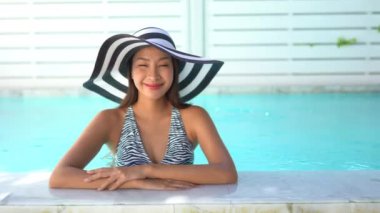 Güzel Asyalı bir kadının oteldeki havuzda dinlenirken çekilmiş görüntüleri.