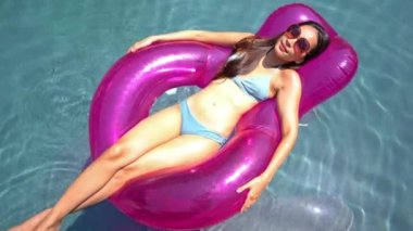 Güzel Asyalı bir kadının oteldeki havuzda dinlenirken çekilmiş görüntüleri.