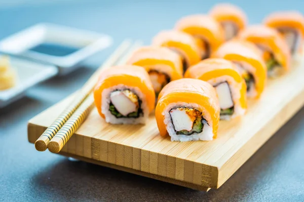 Somon Balık et suşi roll maki ahşap plaka üzerinde