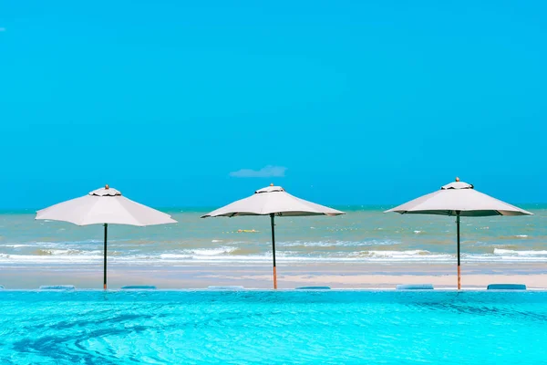 Ombrellone e sedia intorno alla piscina neary mare oceano spiaggia wi — Foto Stock