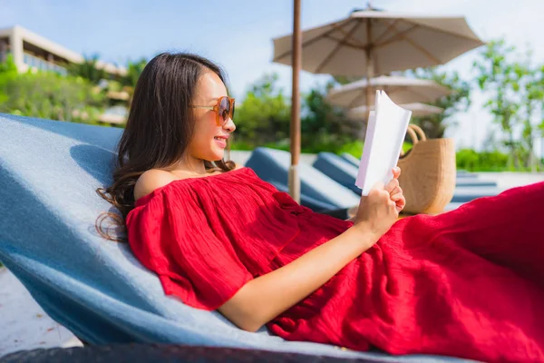 Retrato hermosa joven asiática mujer leyendo libro en natación po —  Fotos de Stock