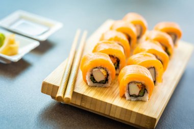 Somon Balık et suşi roll maki ahşap plaka üzerinde