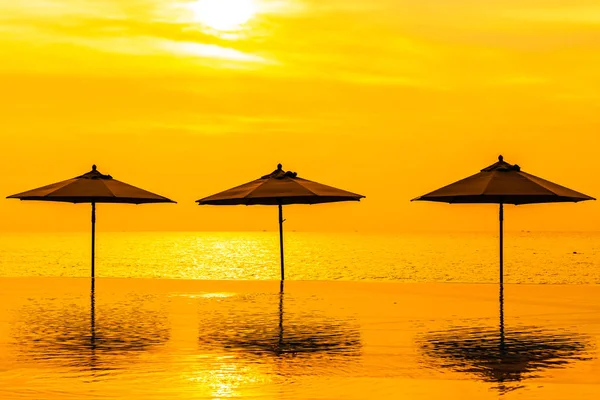 Guarda-chuva e cadeira em torno da piscina neary sea ocean beach at — Fotografia de Stock