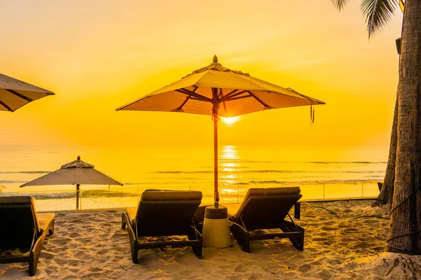 Guarda-chuva e cadeira na bela praia e mar ao nascer do sol tim — Fotografia de Stock