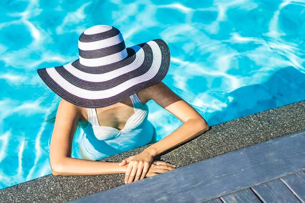 Bonita jovem mulher asiática com chapéu na piscina para viagens — Fotografia de Stock