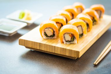 Somon Balık et suşi roll maki ahşap plaka üzerinde