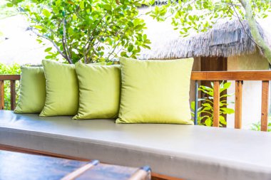 Koltuk koltuğu üzerinde yastık ile masa dekorasyonu vazo bitki