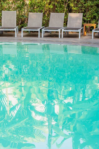 Cadeira vazia em torno da piscina no resort do hotel — Fotografia de Stock