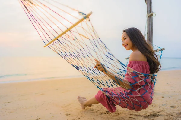 Dikey hamak ile oturan güzel genç Asyalı kadın