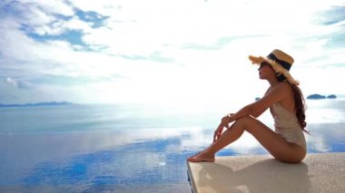 Güzel Asyalı bir kadının oteldeki havuzda dinlenirken çekilmiş görüntüleri.