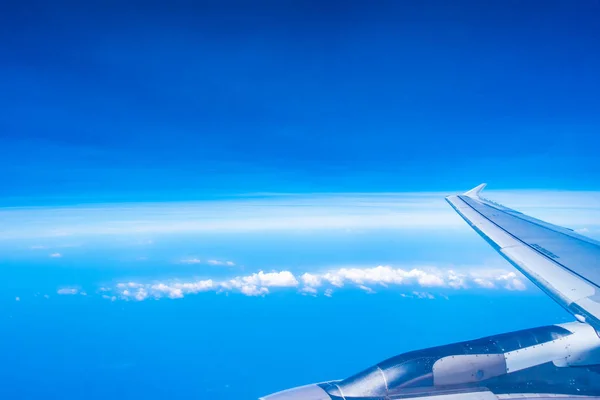 Widok lotniczy skrzydła samolotu z błękitnym niebem — Zdjęcie stockowe