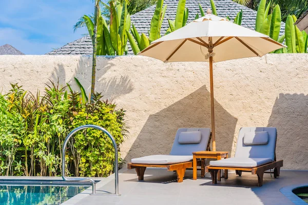 Зонтик и стул у бассейна рядом с пляжем моря wi — стоковое фото