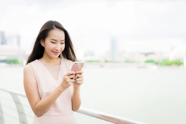 Mujer asiática usando teléfono inteligente o móvil para hablar o texto — Foto de Stock