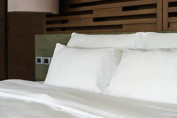 Красива розкішна зручна подушка на ліжку зі світловою лампою — стокове фото
